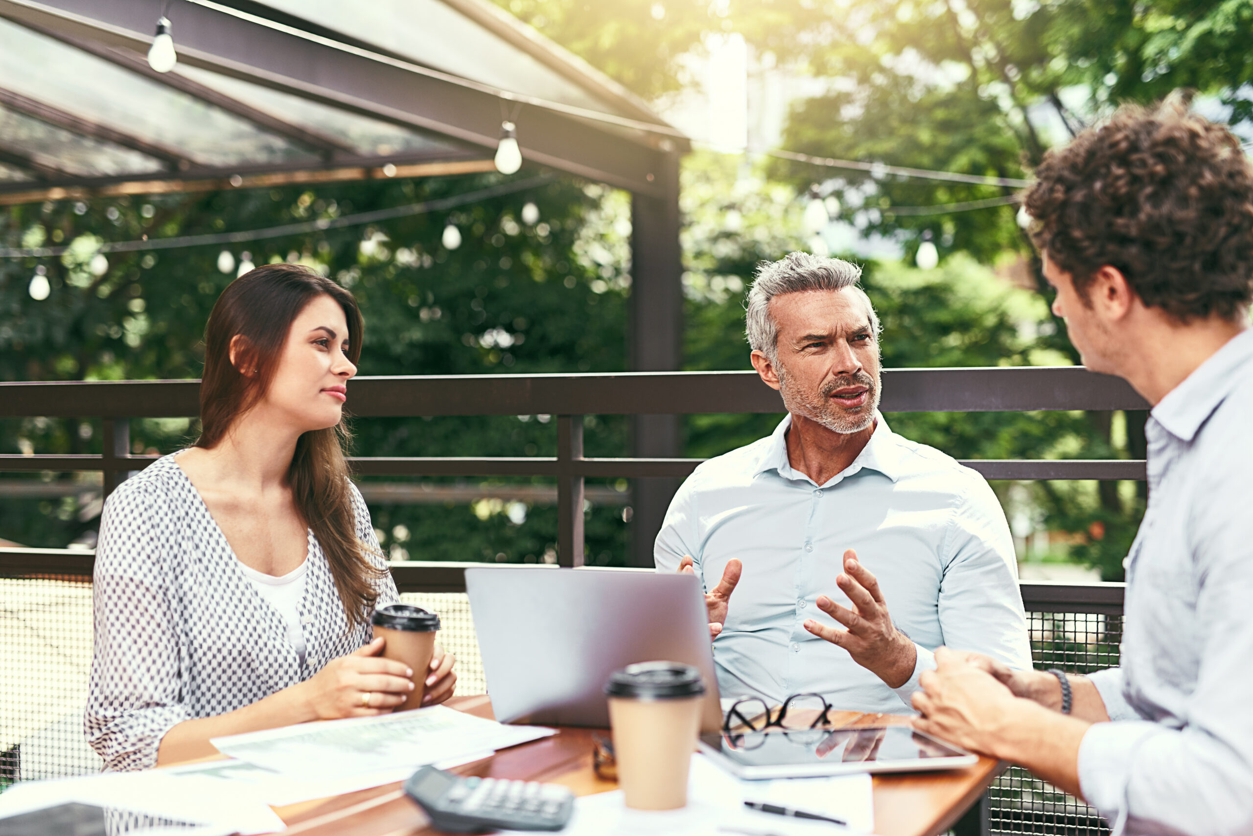 Business owners discussing plans together at an outdoor cafe
